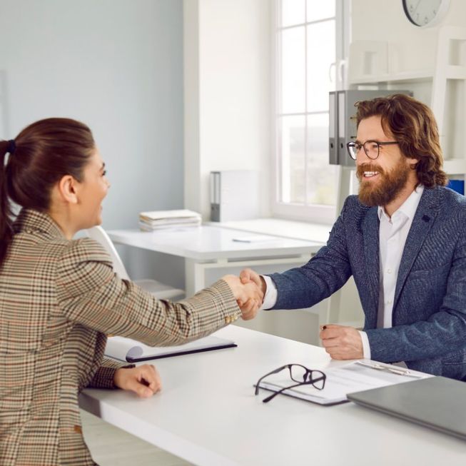 dos personas entrelazando la mano en una oficina